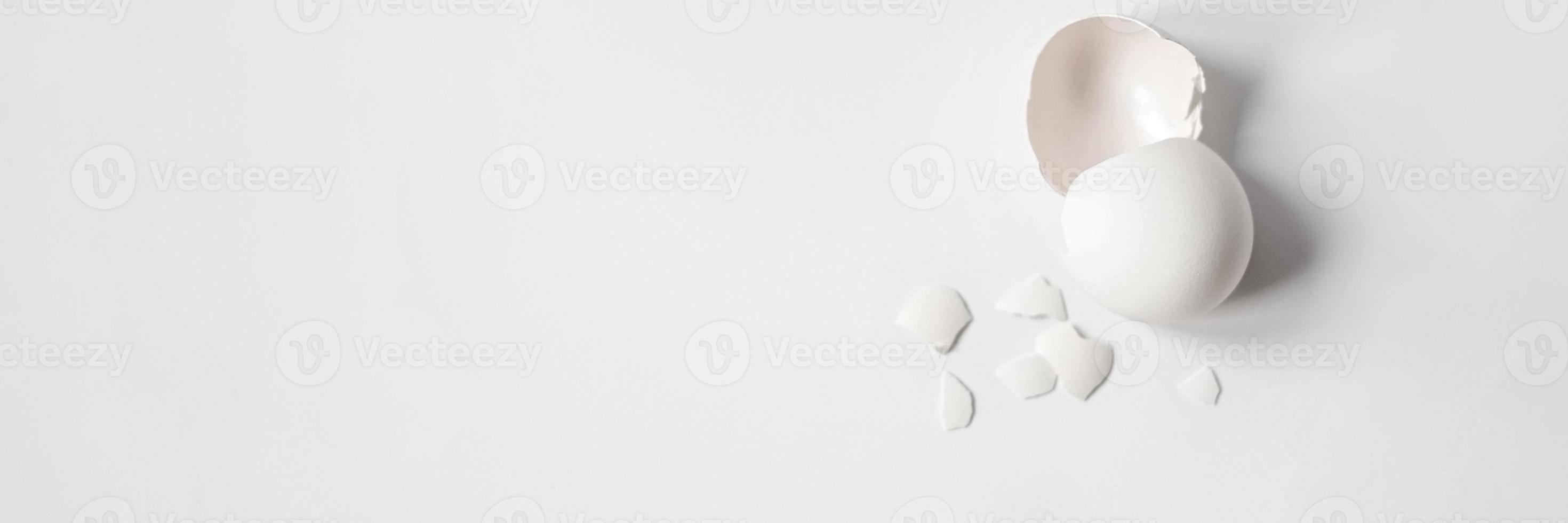 vitt äggskal av ett trasigt kycklingägg med skärvor isolerad på en vit bakgrund. påsk.vy från ovan. banner foto