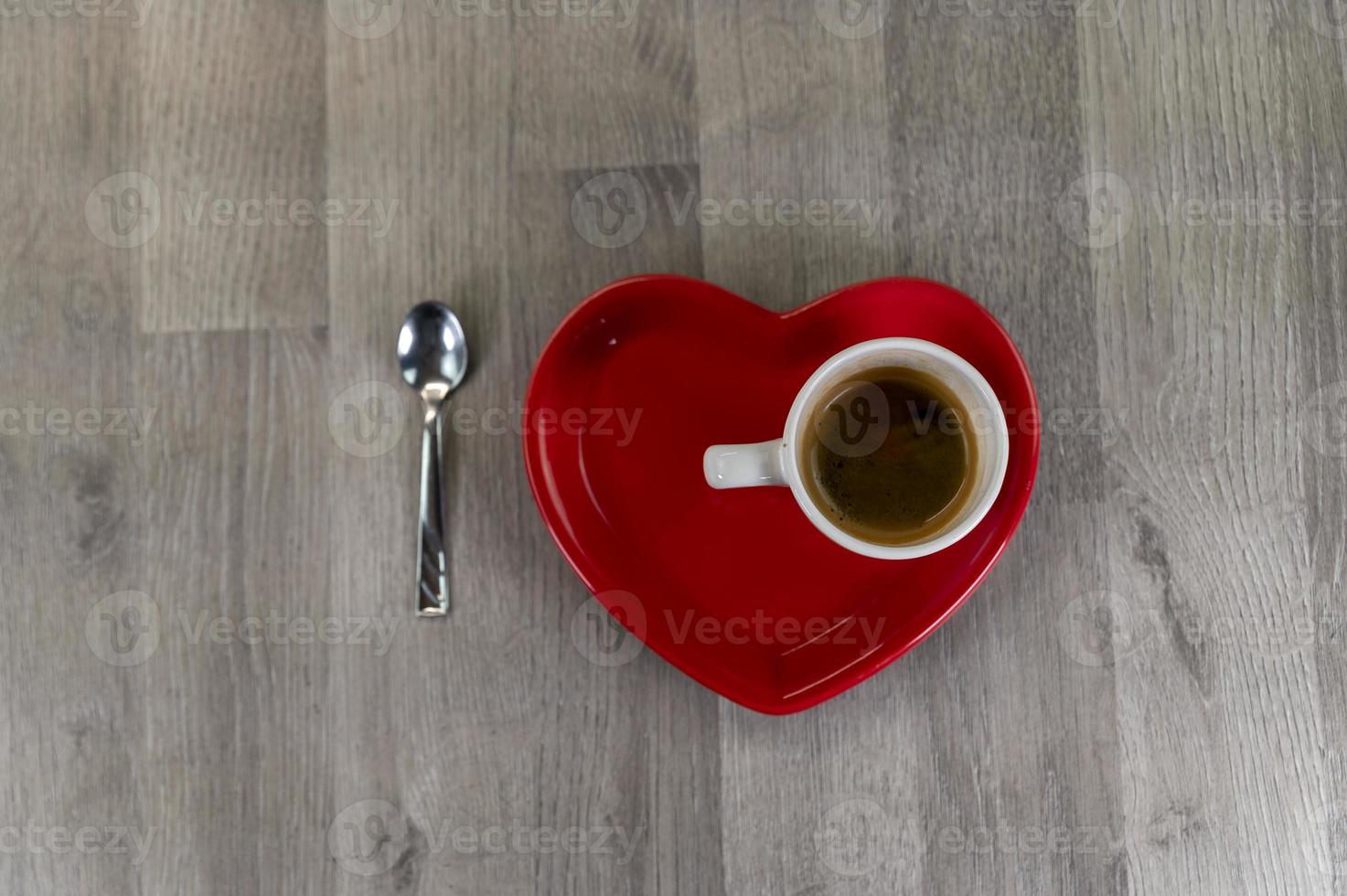 en kopp kaffe med ett hjärtformat fat foto