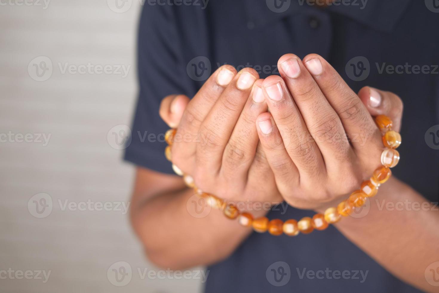 muslimsk man håller handen i berande gester under ramadan, närbild foto