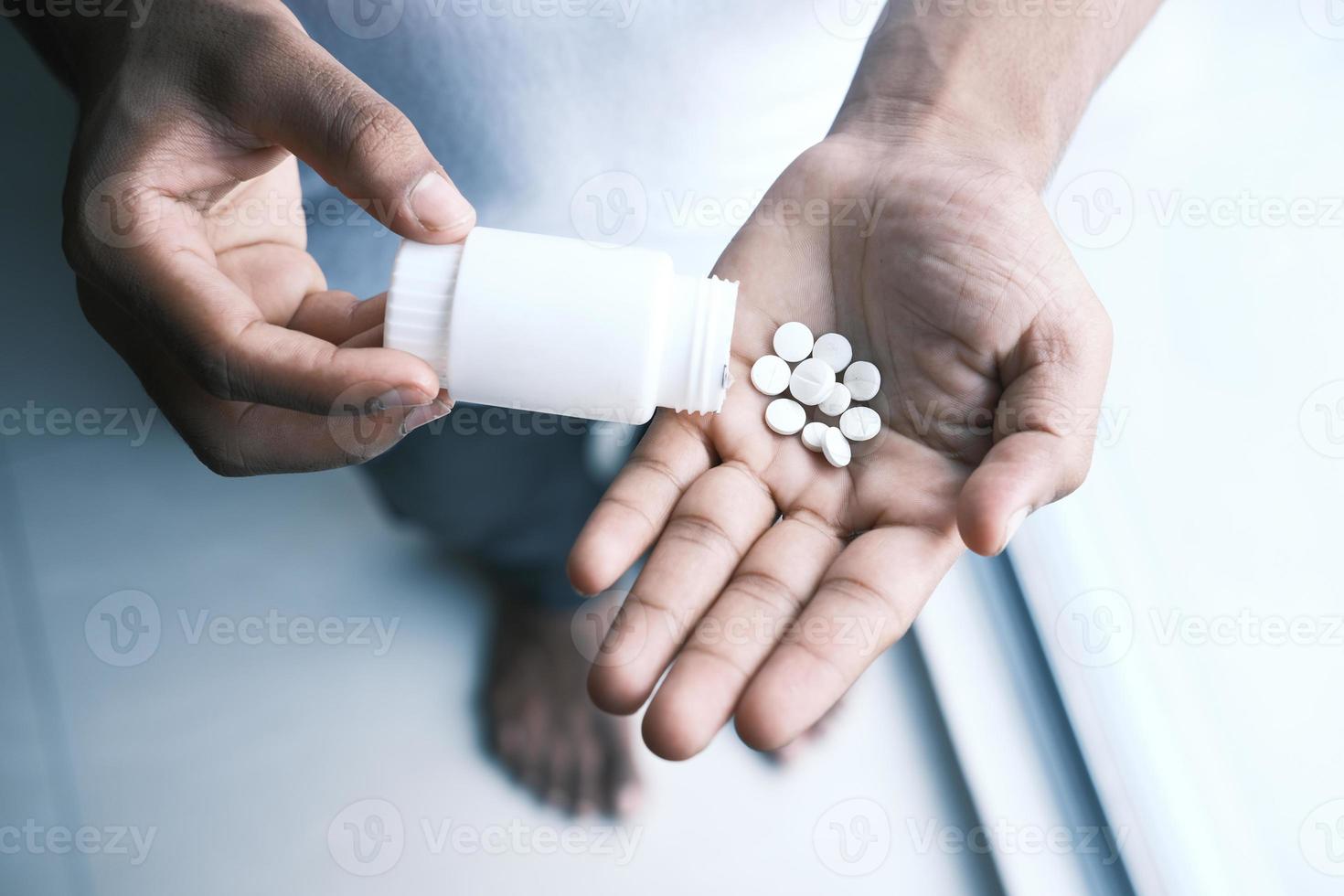 mans hand med medicin som spillts ut ur pillerbehållaren foto