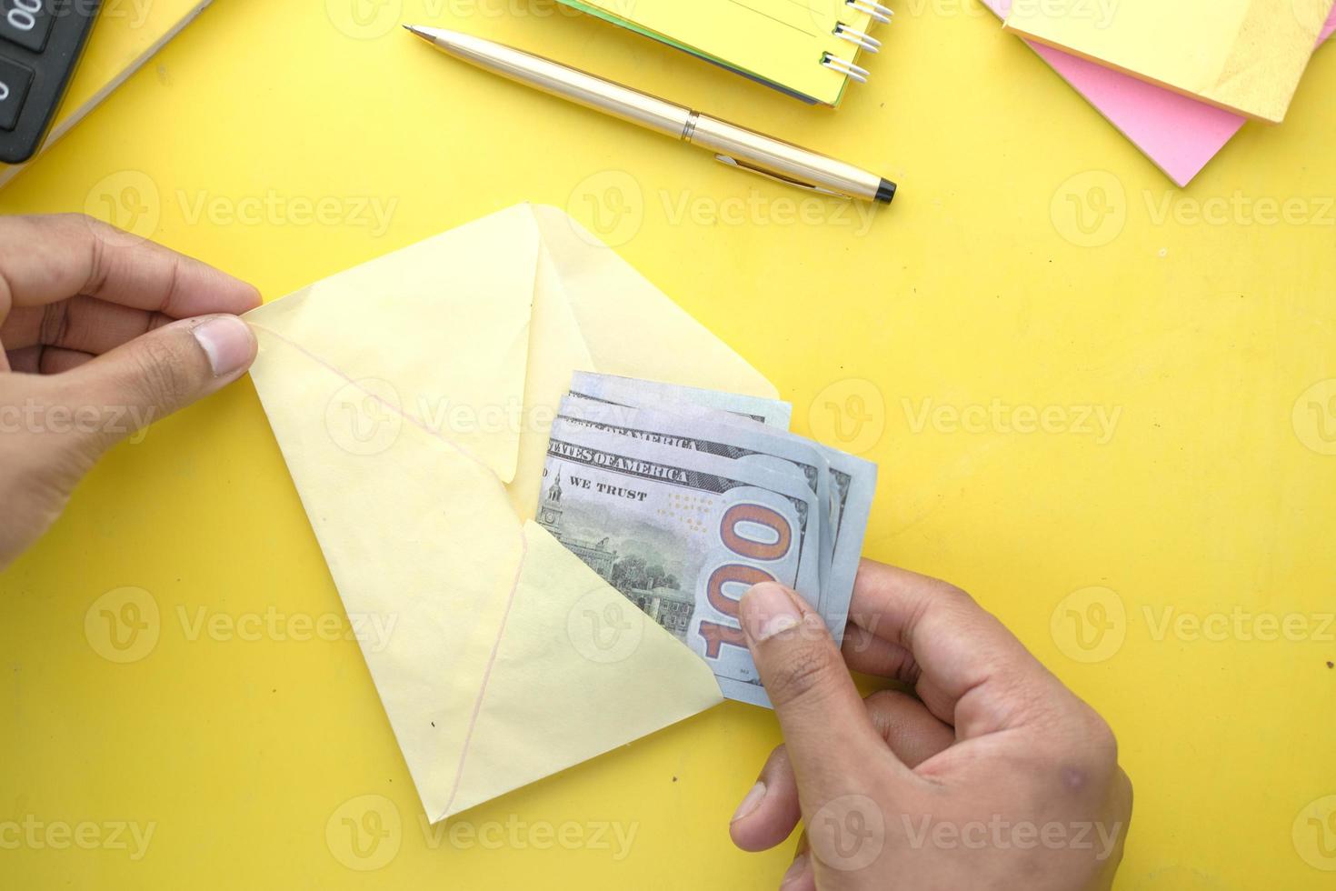 person hand lägga kontanter i ett kuvert foto