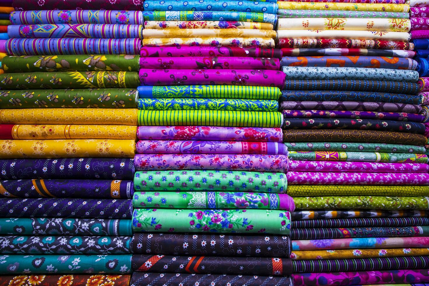 konstnärlig mängd skugga tona textil- tryckt färger tyger staplade på detaljhandeln affär hylla till försäljning foto