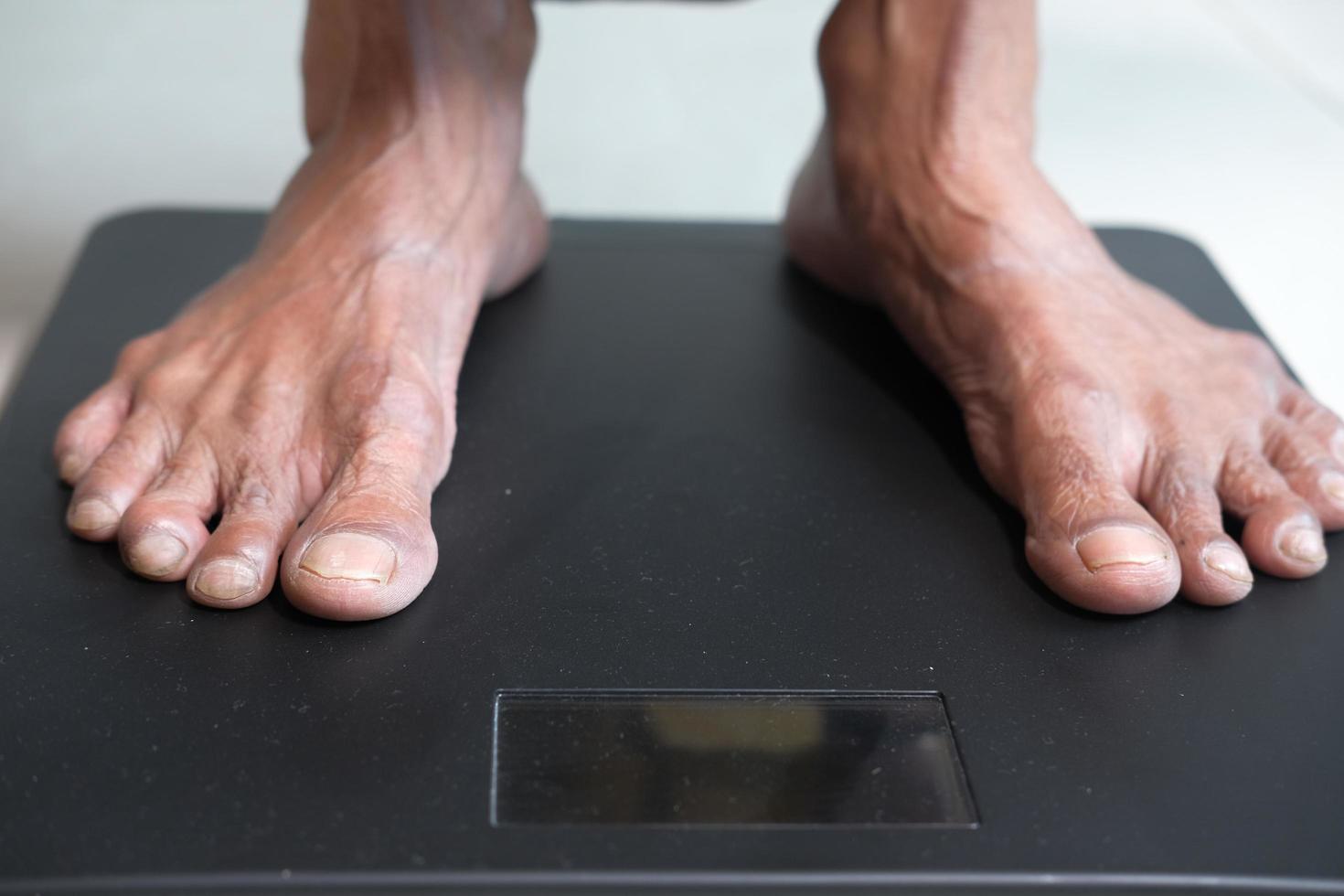 äldre kvinnors fötter på vikt skala på nära håll foto
