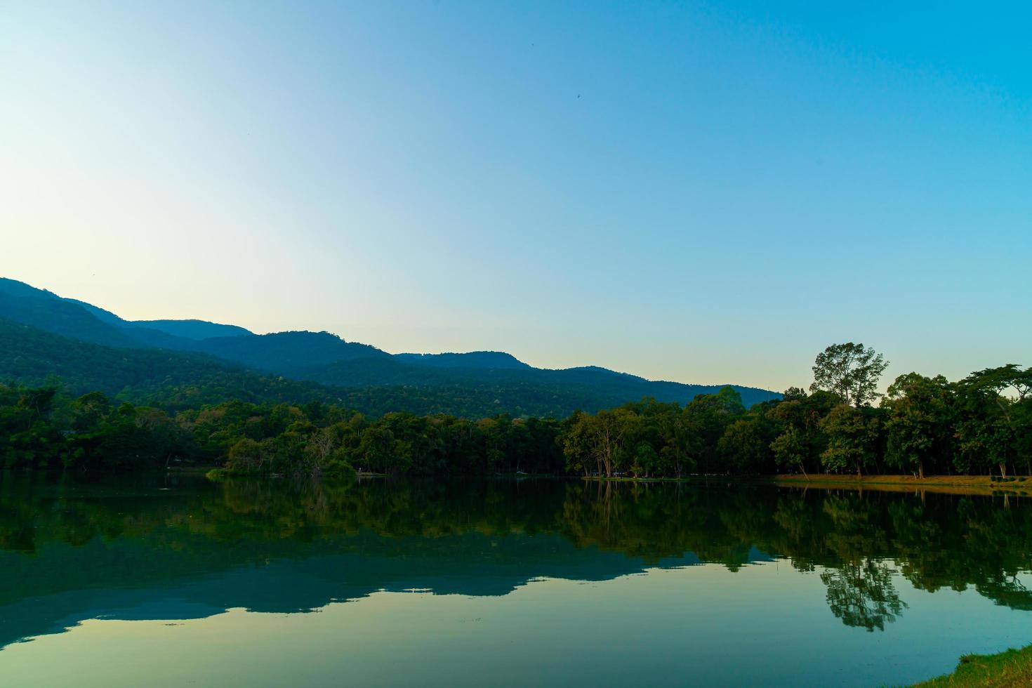 ang kaew sjö vid Chiang Mai universitet med skogsklädda berg foto