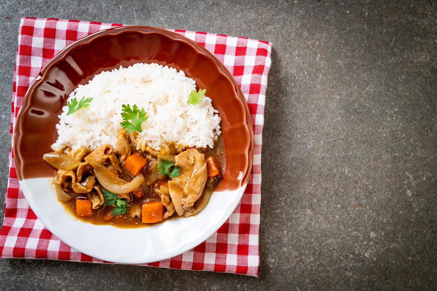 japanskt curryris med skivat fläsk, morot och lök foto