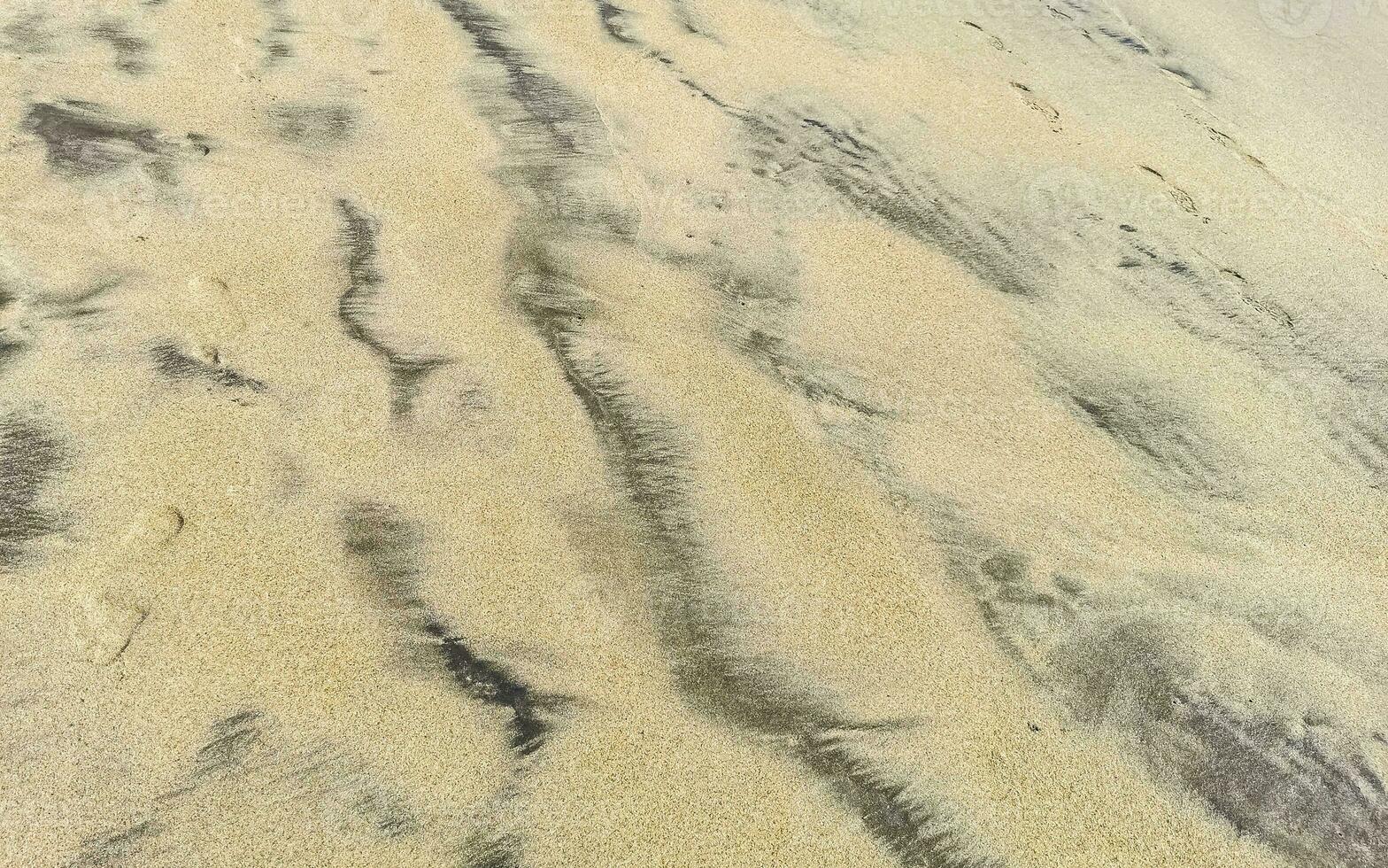 våt strand sand vatten och vågor textur och mönster i Mexiko. foto