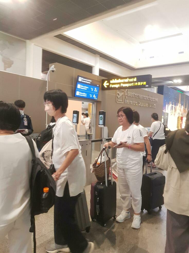 Bangkok, thailand på juli 9, 2023. flera människor är foder upp till kolla upp utländsk pass till stiga på invandring disken. foto