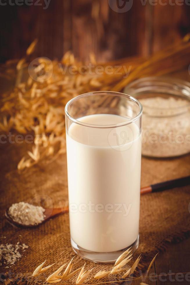 glas havre mjölk på en trä bakgrund. foto