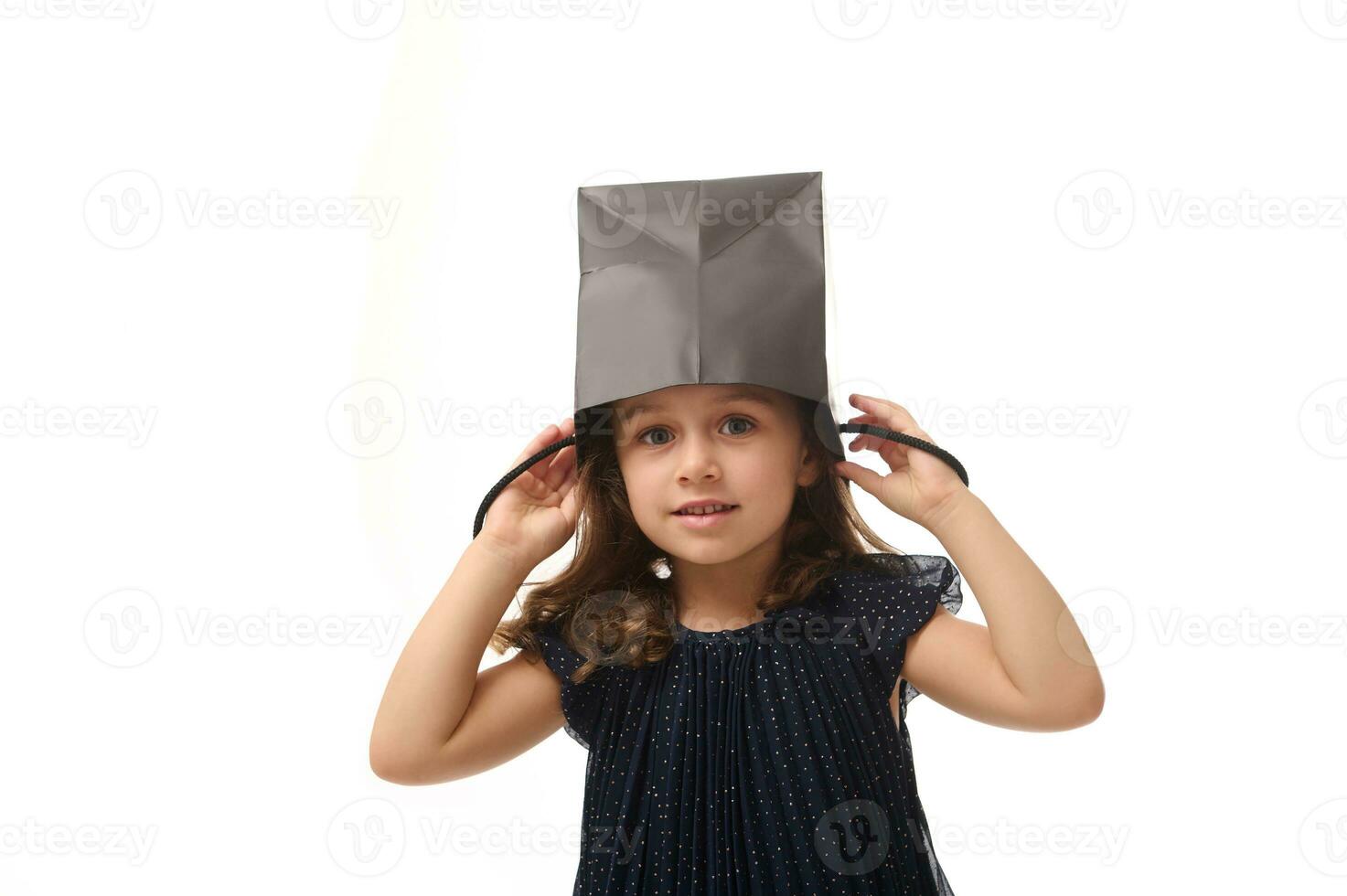 porträtt av skön europeisk flicka har roligt, sätta en svart handla paket på henne huvud, ser på kamera, isolerat över rosa bakgrund med kopia rymd, svart fredag begrepp foto