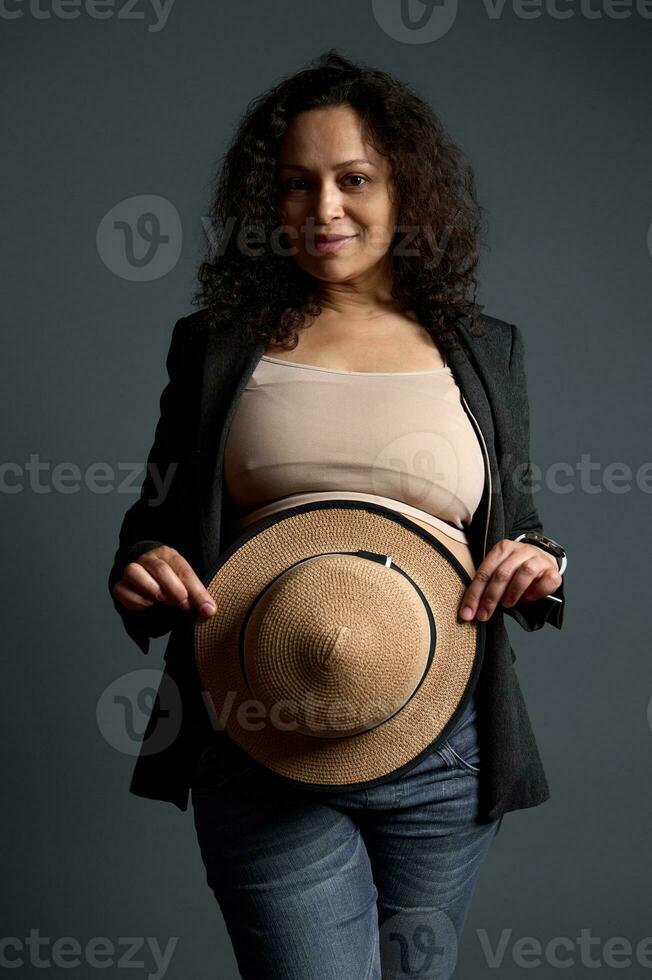 charmig gravid kvinna dölja henne stor mage med en sugrör hatt. skön graviditet. kvinnors hälsa. gynekologi begrepp foto