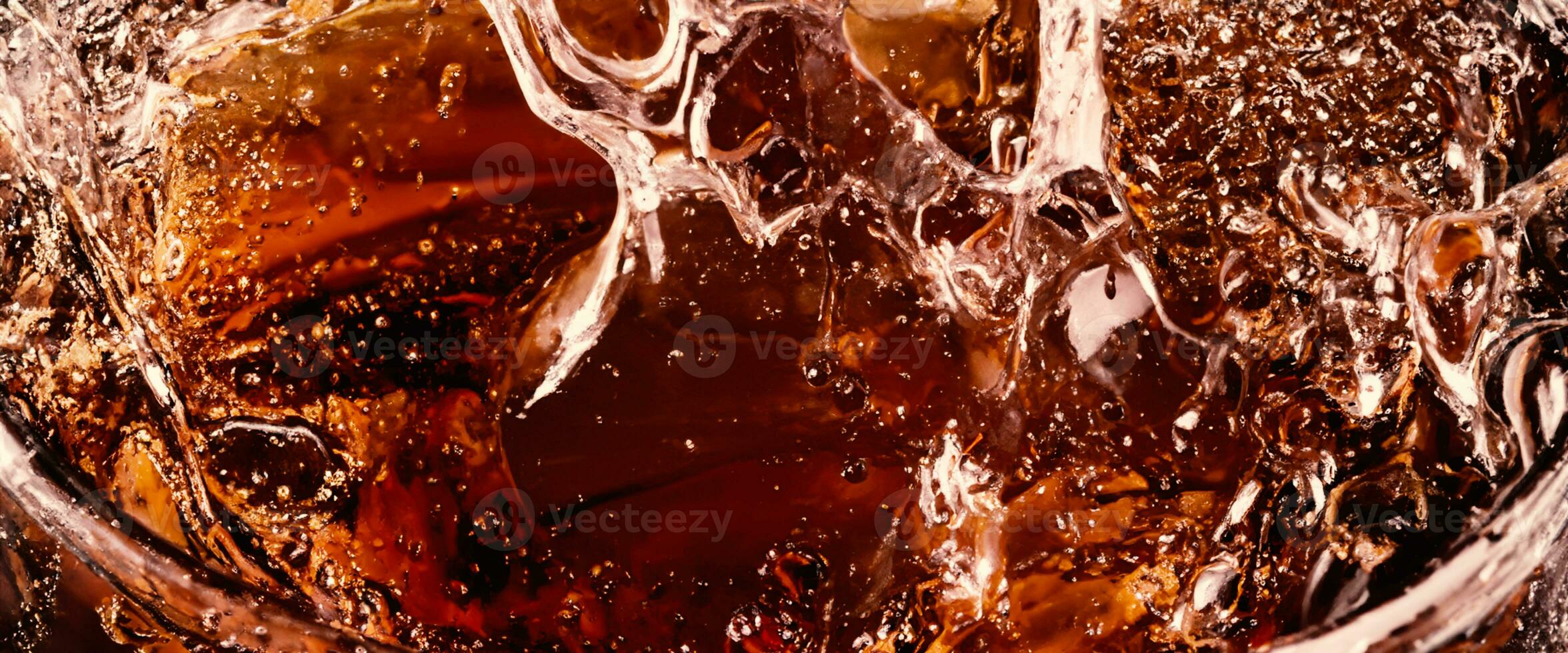 stänk av cola och is. cola soda och is stänk gnistrande eller flytande upp till topp av yta. stänga upp av is i cola vatten. textur av karbonat dryck med bubblor i glas. kall dryck bakgrund foto