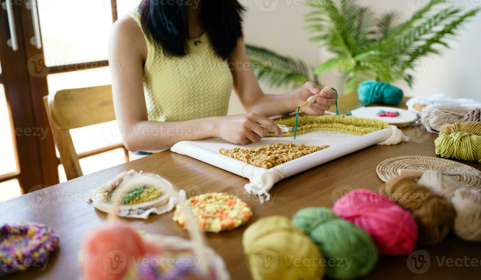 stansa nål. asiatisk kvinna framställning handgjort hobby stickning i studio verkstad. designer arbetsplats handgjort hantverk projekt diy broderi begrepp. foto