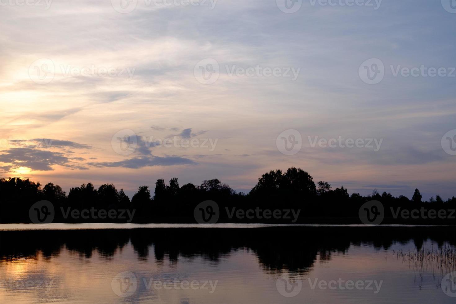 lugn sjö vid solnedgången foto