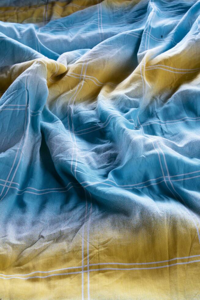färgrik filt i ett obäddad säng och betning ljus foto