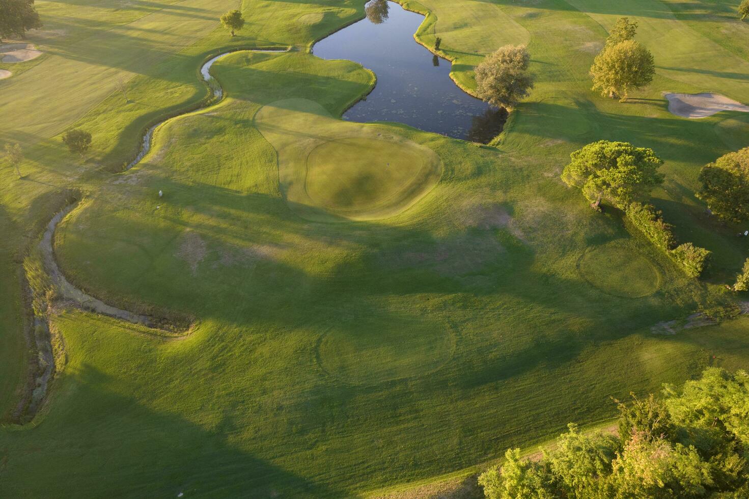 antenn se av en grön golf kurs på solnedgång foto
