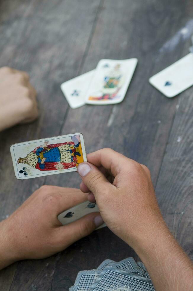 en person är spelar kort med en däck av kort foto