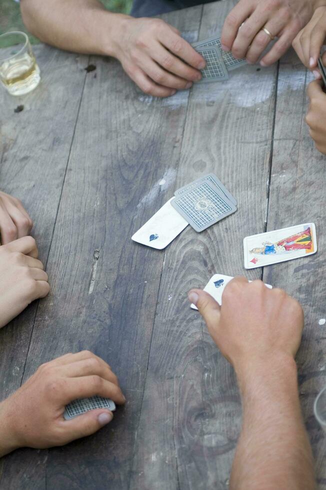 en person är spelar kort med en däck av kort foto