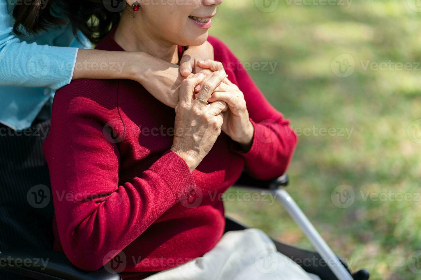 familj relation asiatisk senior kvinna i rullstol med Lycklig dotter innehav vårdgivare för en hand medan utgifterna tid tillsammans foto