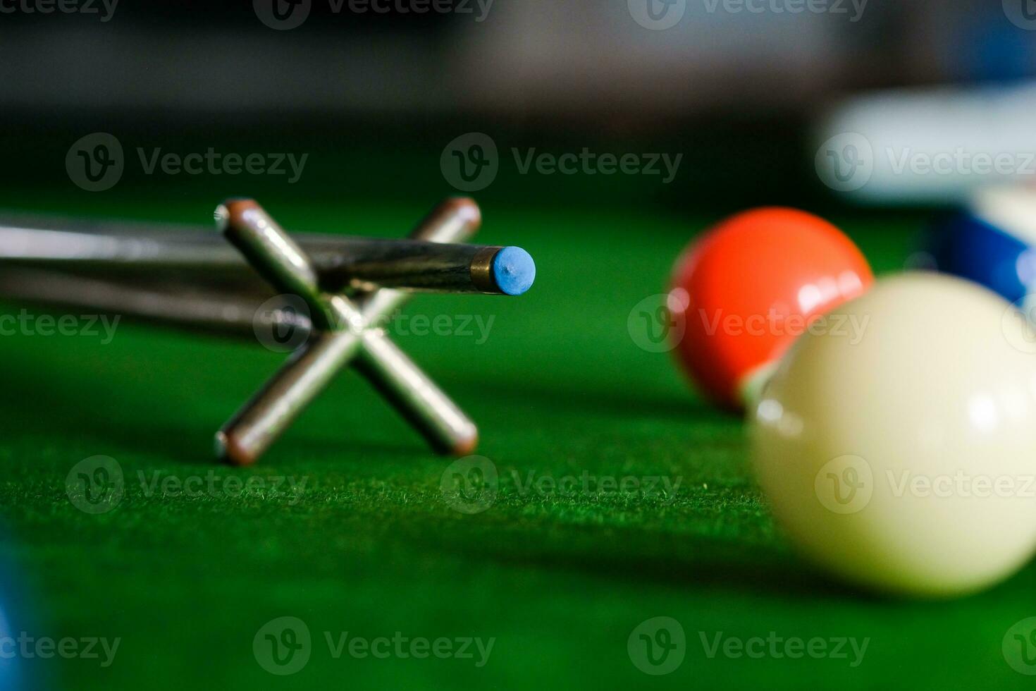 mannens hand och kö ärm spelar snooker spel eller framställning siktar till skjuta slå samman bollar på en grön biljard tabell. färgrik snooker bollar på grön fris. foto