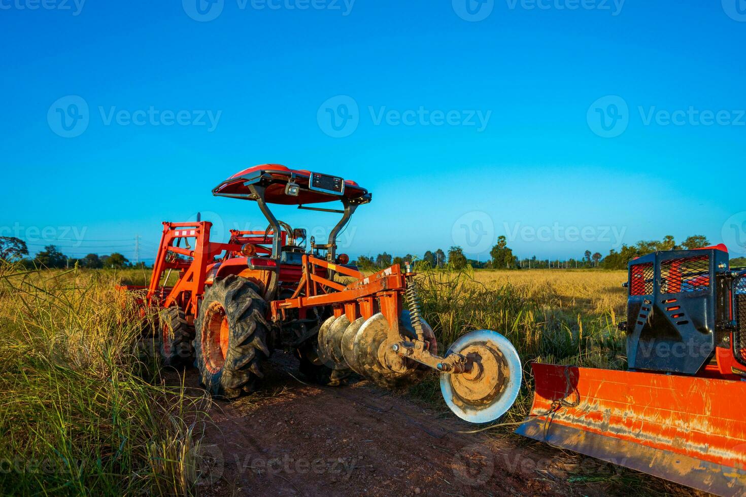 jordbruks maskineri i de ris fält på solnedgång foto
