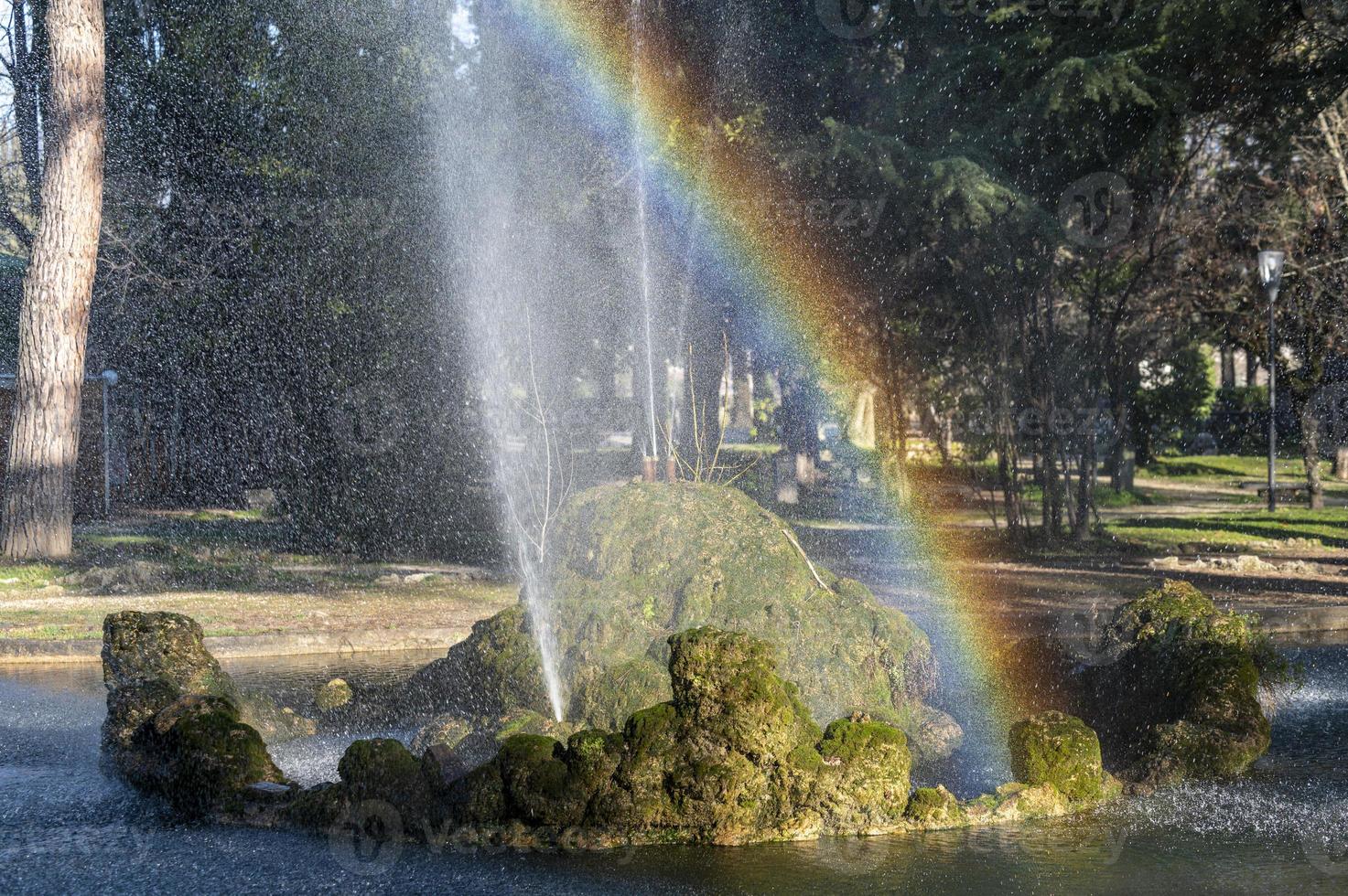 fontän med regnbåge i parken foto