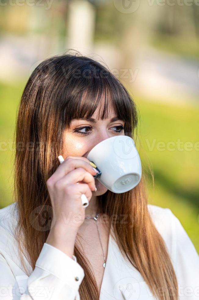 flicka som dricker en kopp te i trädgården foto