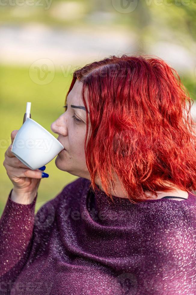 flicka som dricker en kopp te i trädgården foto