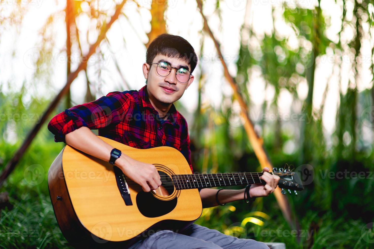 man spelar gitarr utanför foto