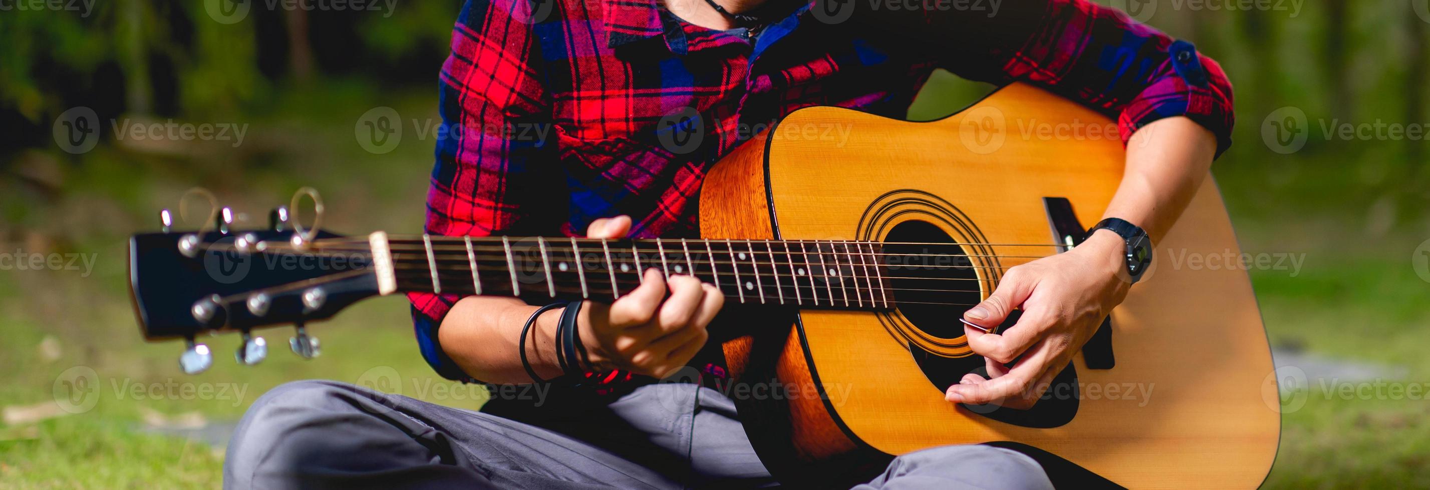 person som spelar gitarr utanför foto