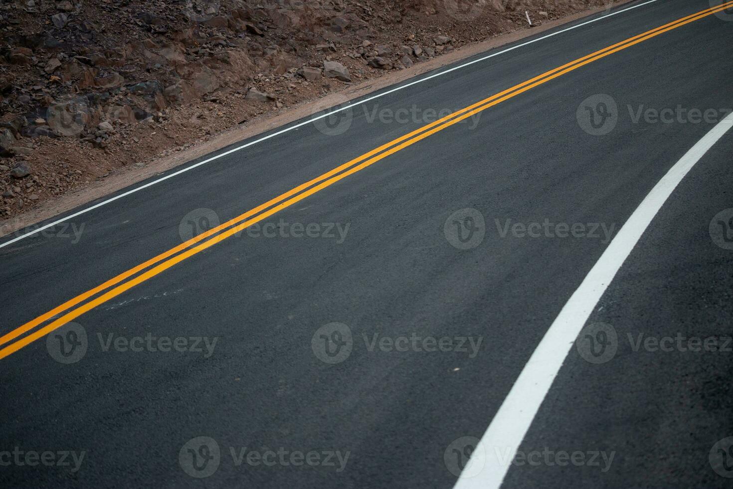 de asfalt väg har gul och vit trafik rader korsning de berg. foto