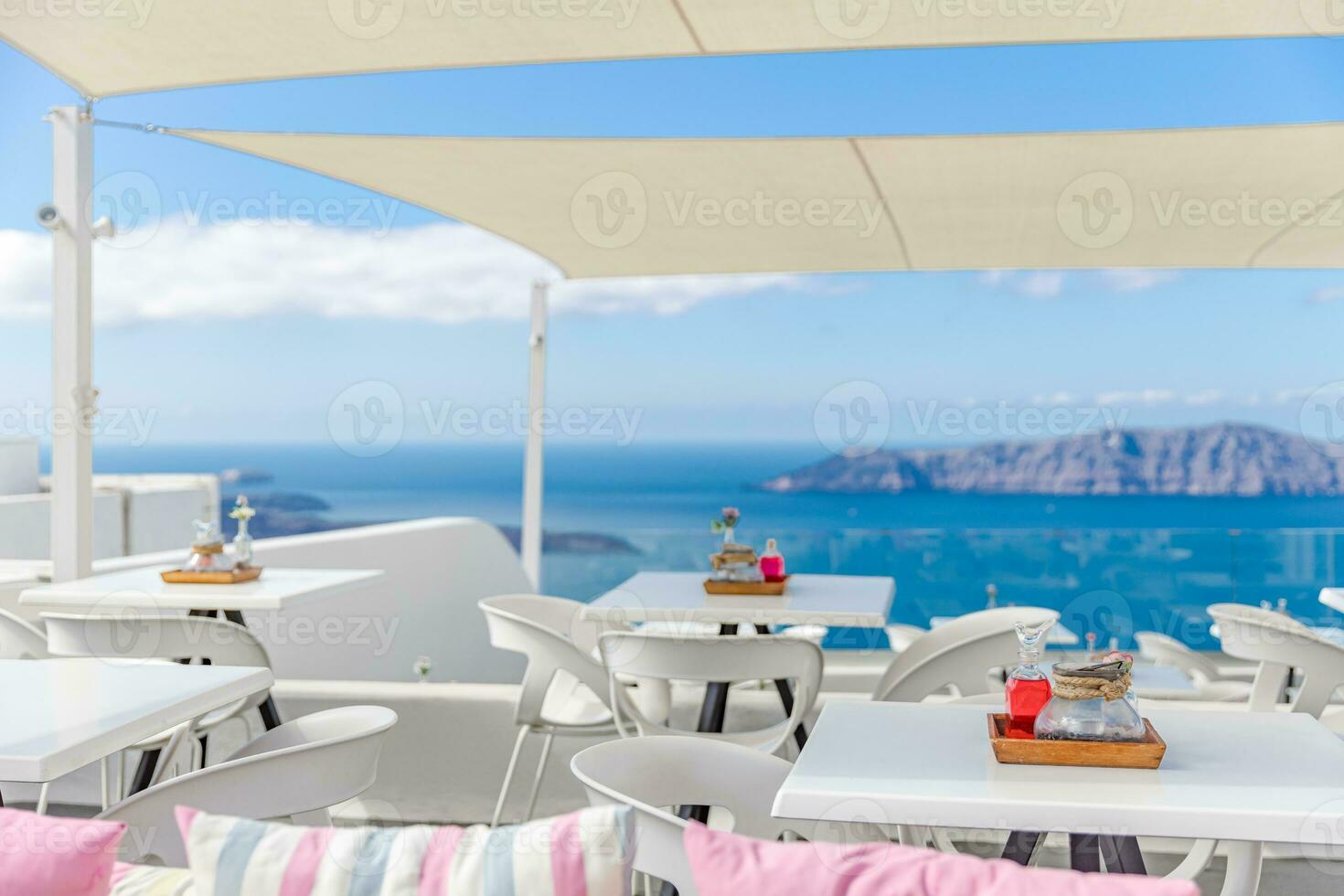 Kafé på de terrass utsikt de hav. santorini ö, grekland. utmärkt sommar humör, utomhus- restaurang. romantisk vibrafon, sommar färger under vit tält och blå himmel foto