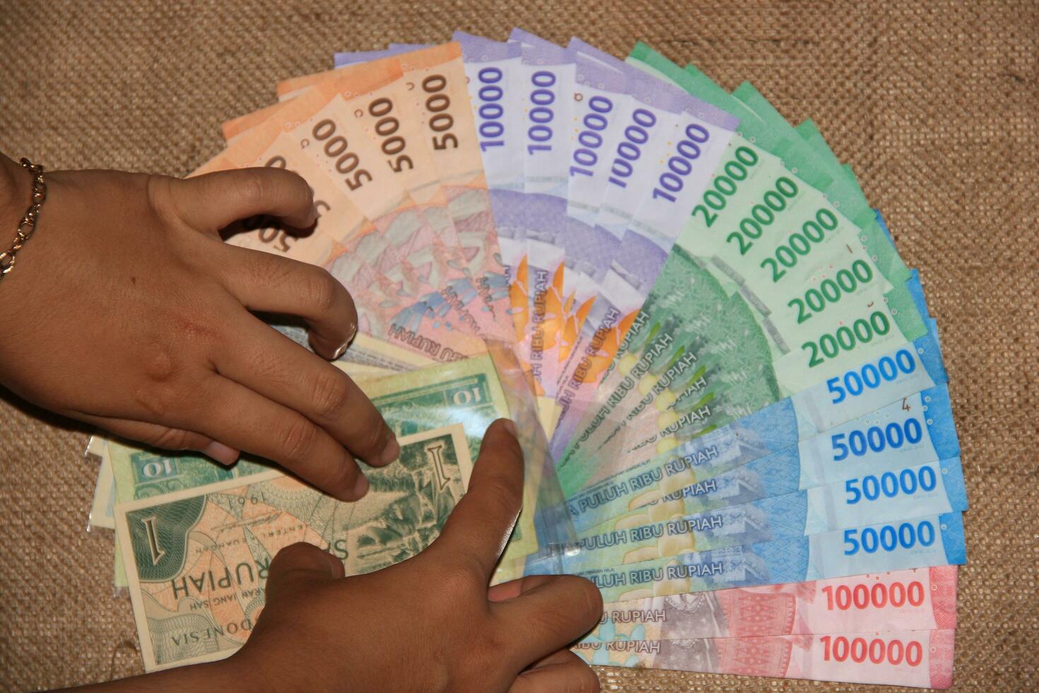 bandung, indonesien - juli 2023 topp se av vuxen händer arrangera rupiah sedlar för bröllop hemgift. foto