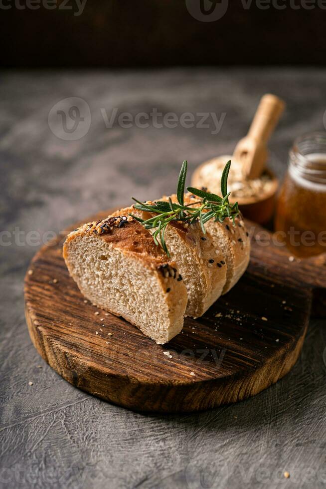 hantverkare bröd hela vete baguette vit mjölk och honung på rustik trä- styrelse och abstrakt tabell. surdeg bröd foto
