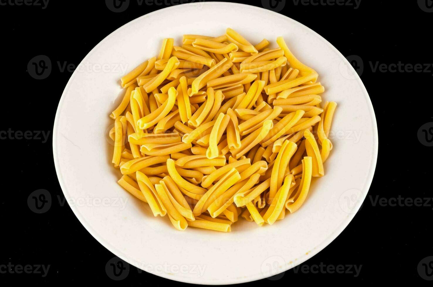 en vit tallrik fylld med gul pasta foto