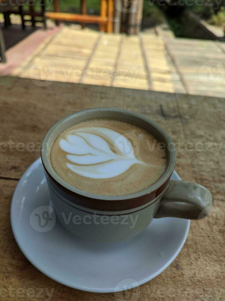 trevlig textur av latte konst på varm latte kaffe . mjölk skum i hjärta form blad träd på topp av latte konst från professionell Barista konstnär foto