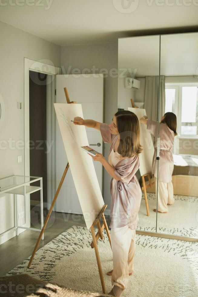 Söt begåvad kvinna målare målning på staffli framställning färgrik skisser skapande underbar konst. skön kvinna konstnär målning med pastell. kreativitet och fantasi begrepp foto