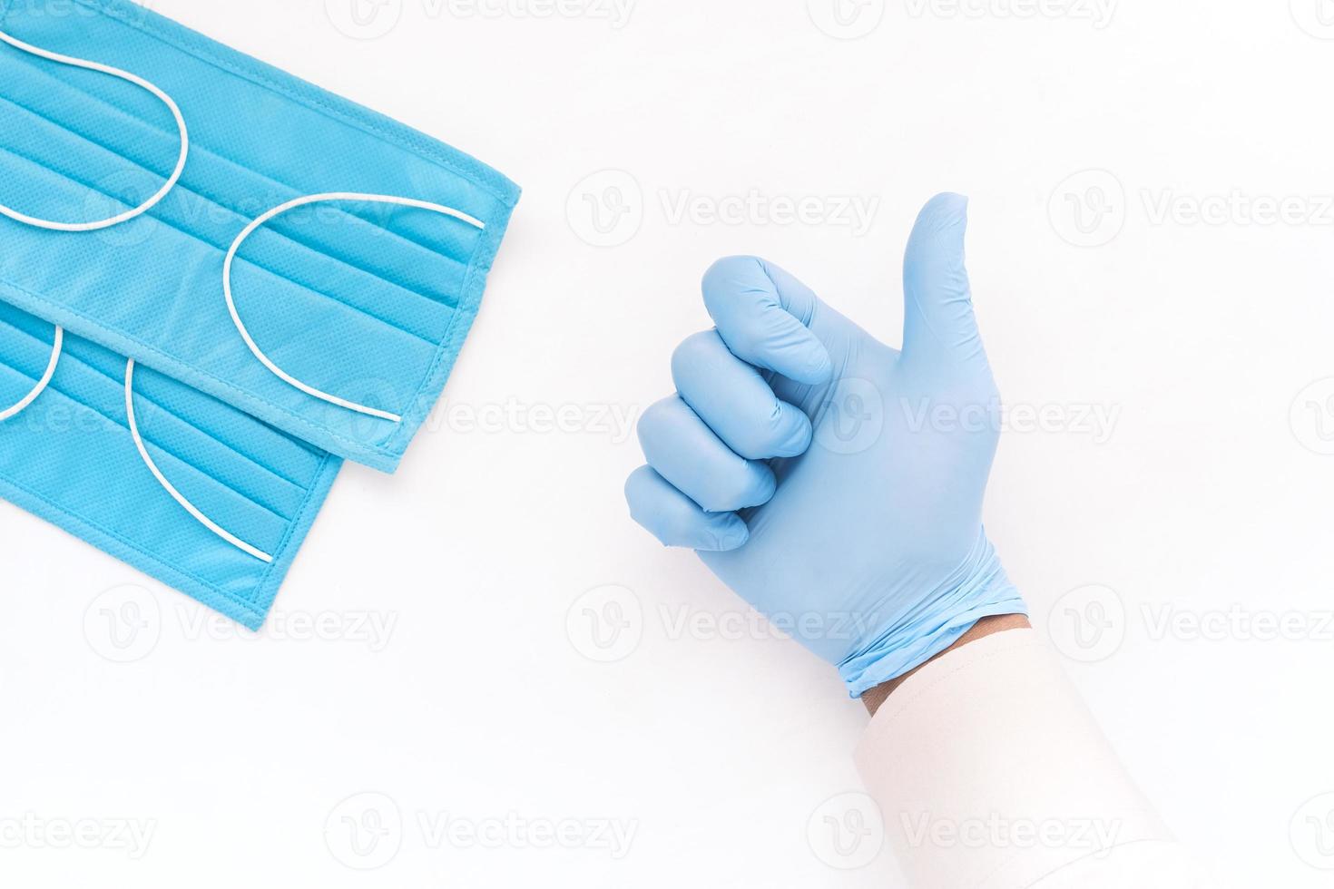lämna in medicinska handskar som visar en tumme upp på vit bakgrund foto