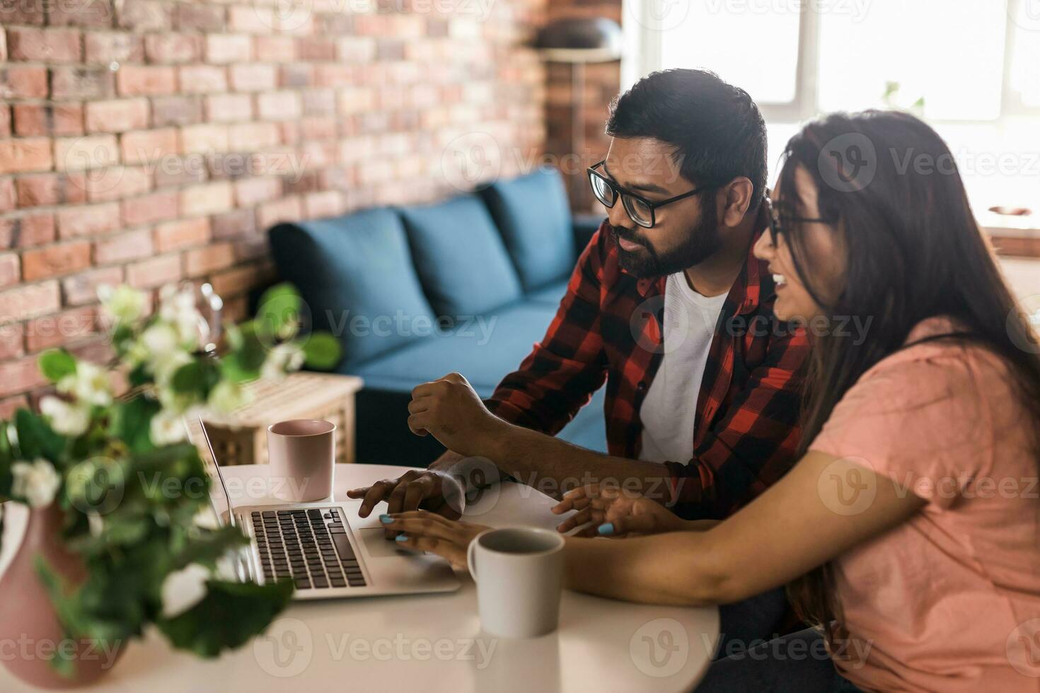latino eller indisk man och kvinna par använda sig av deras bärbar dator i de levande rum till göra video samtal. video ring upp och uppkopplad chatt med familj foto