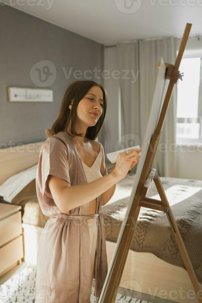 Söt begåvad kvinna målare målning på staffli framställning färgrik skisser skapande underbar konst. skön kvinna konstnär målning med pastell. kreativitet och fantasi begrepp foto