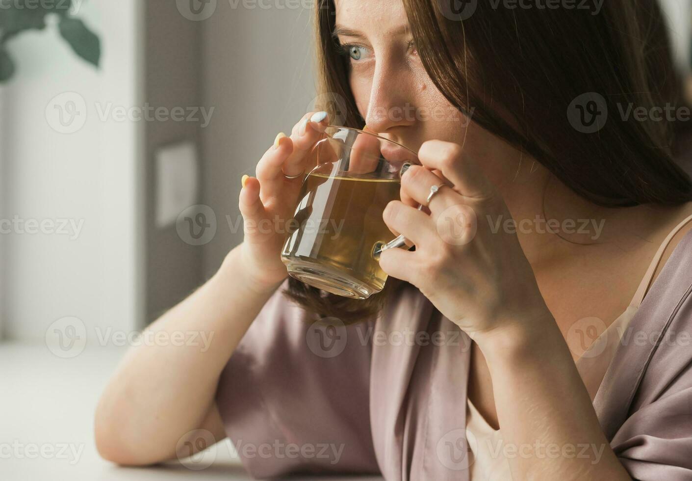 ung kvinna Sammanträde på stol på Hem och dricka te, tillfällig stil inomhus- skjuta. närbild porträtt foto
