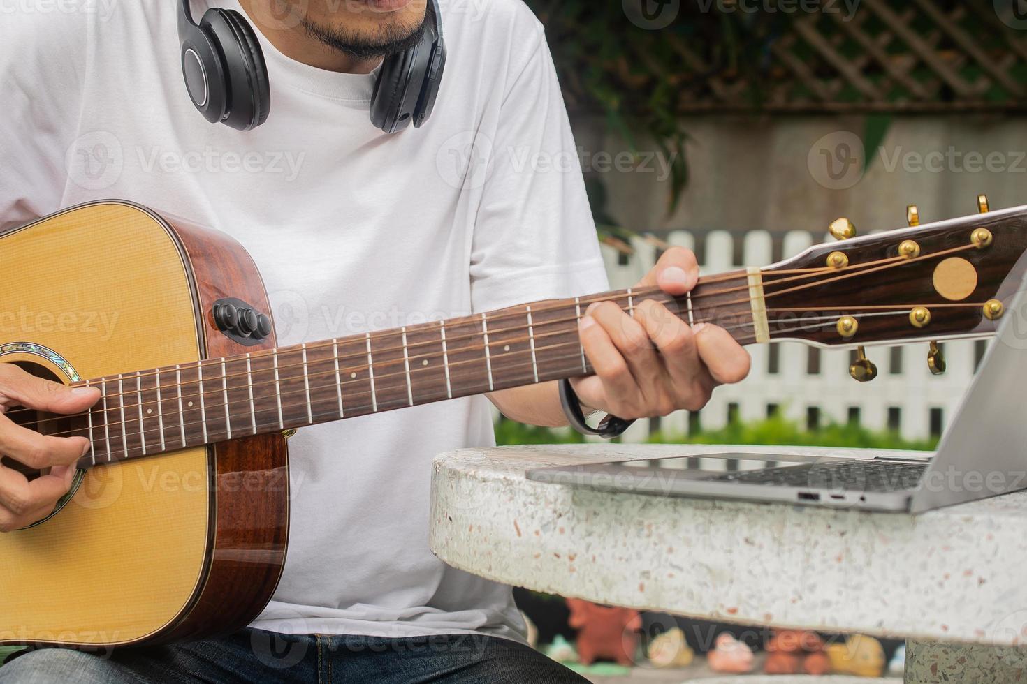 man spelar gitarr och lär sig gitarrklass online foto