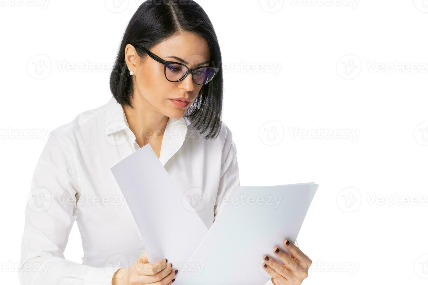 fundersam ung företag kvinna i glasögon och vit skjorta på henne skrivbord med papper dokument. prestation företag karriär begrepp. foto