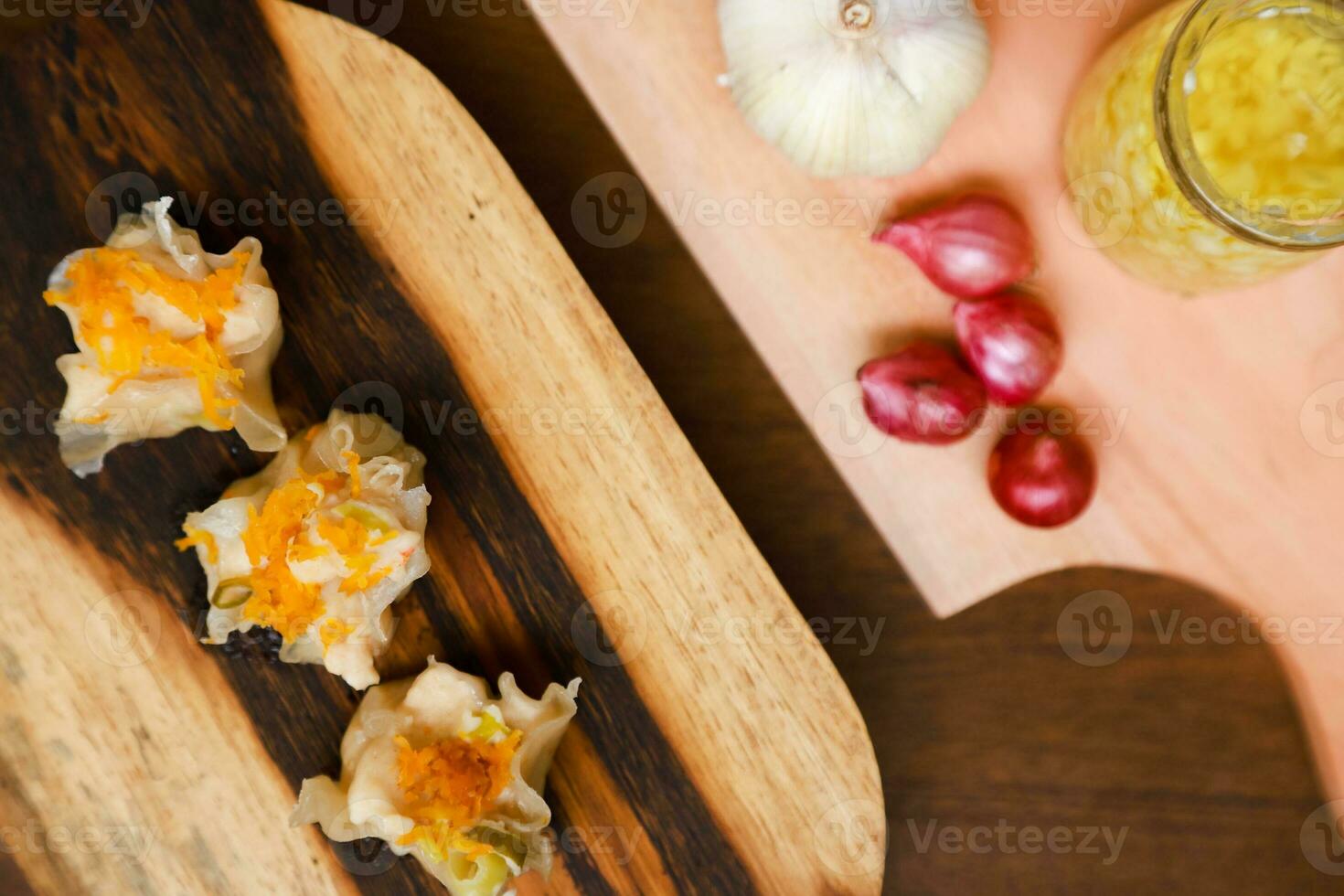 platt lägga av traditionell kinesisk dimsum med sås och örter tjäna på en trä- tabell foto