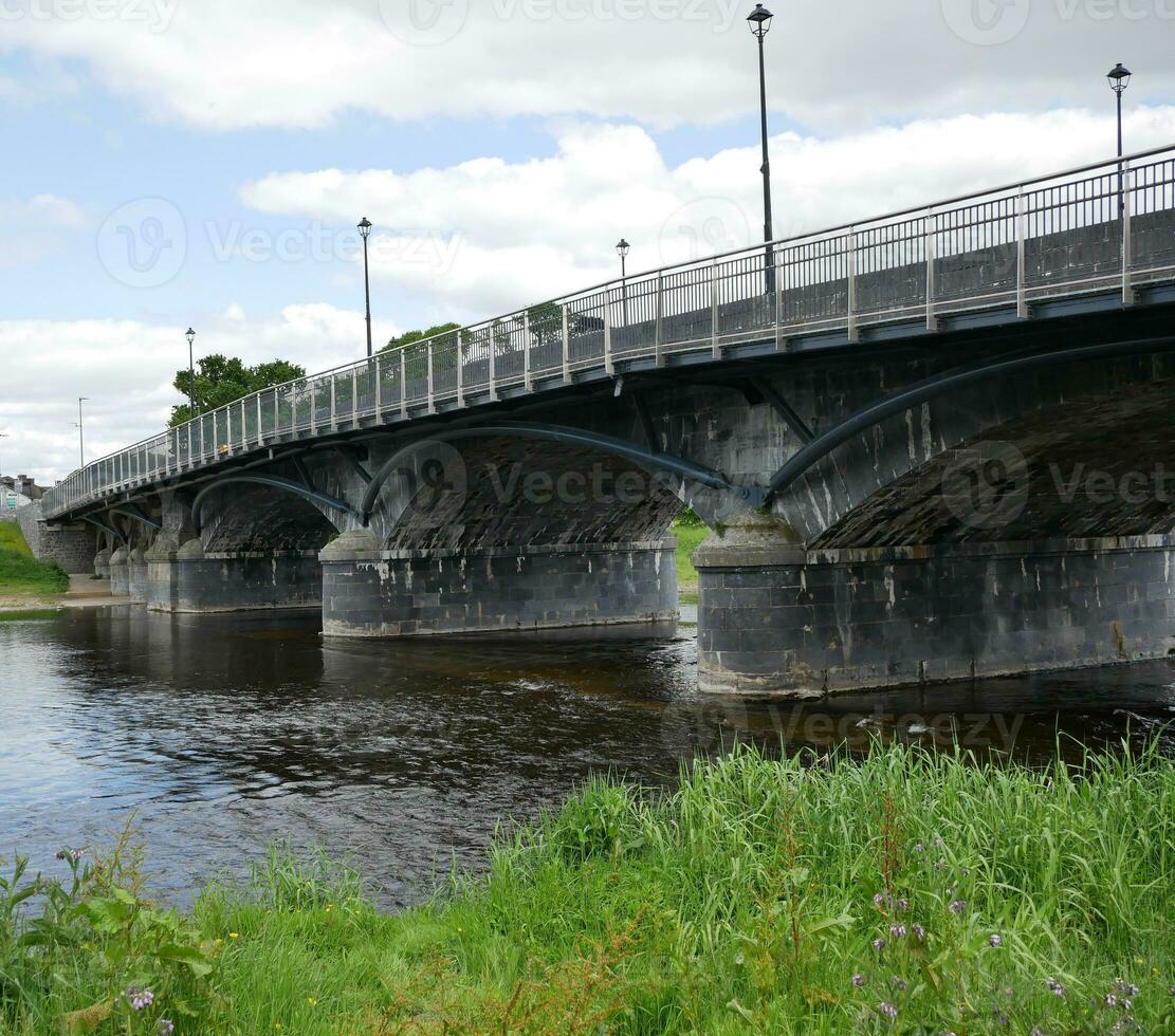 gammal sten bro i Irland, gammal bro över de flod bakgrund foto