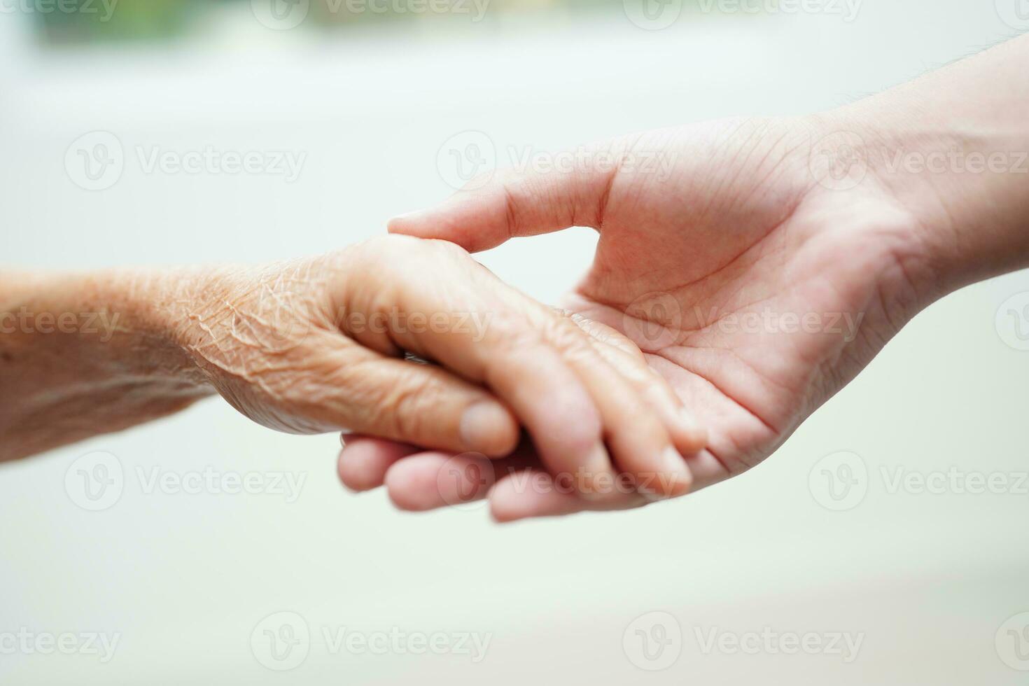 asiatisk ung pojke innehav gammal mormor kvinna hand tillsammans med kärlek och vård. foto