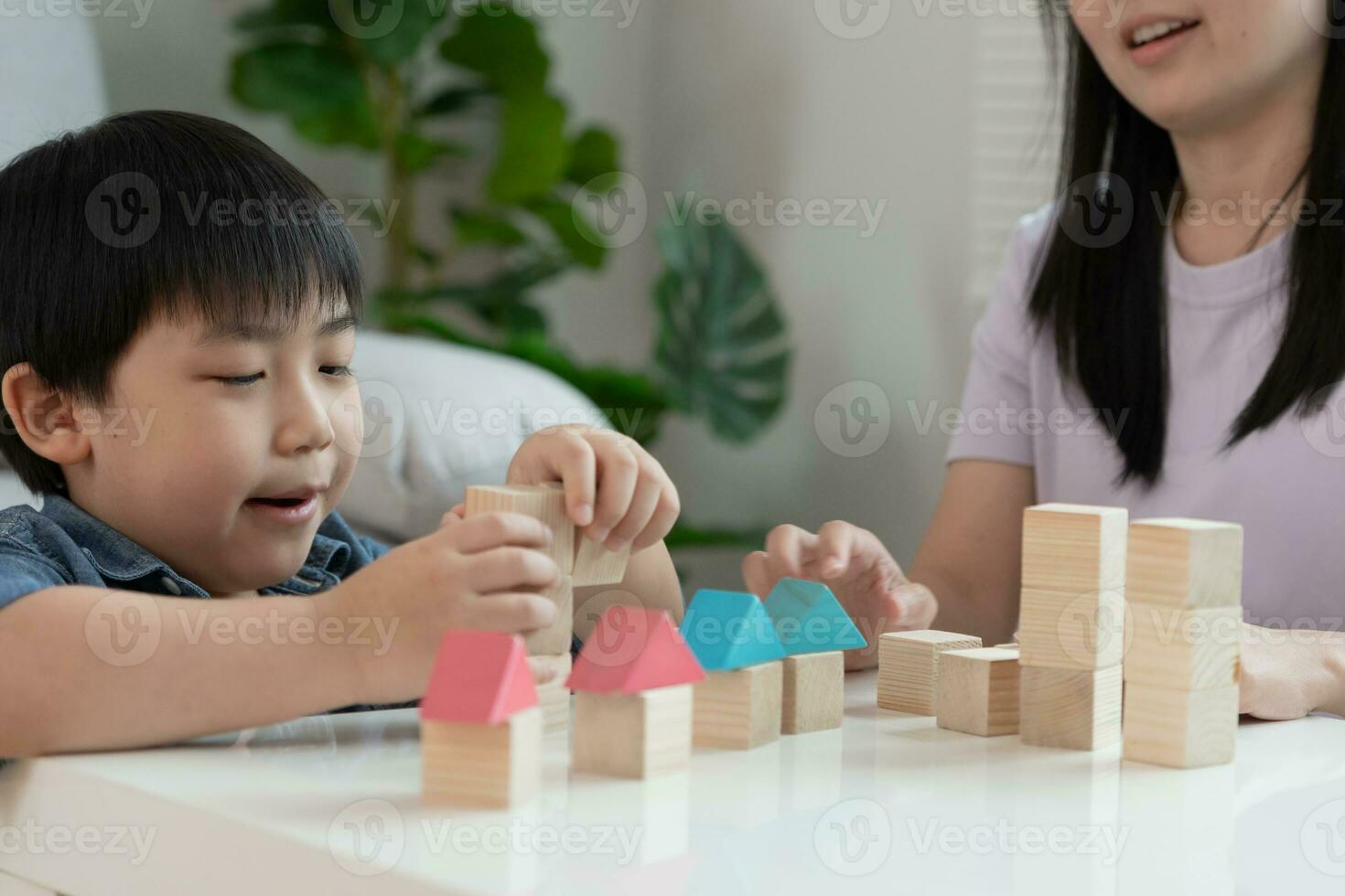 Lycklig Asien mor spela och lära sig leksak block med de liten flicka. rolig familj är Lycklig och upphetsad i de hus. mor och dotter har roligt utgifterna tid tillsammans. Semester, aktivitet, utveckling foto
