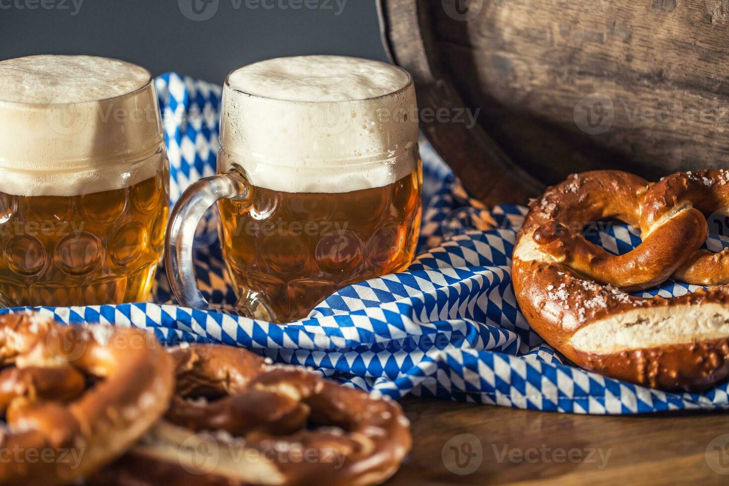 oktoberfest två öl med pretzel trä- tunna och blå bordsduk foto