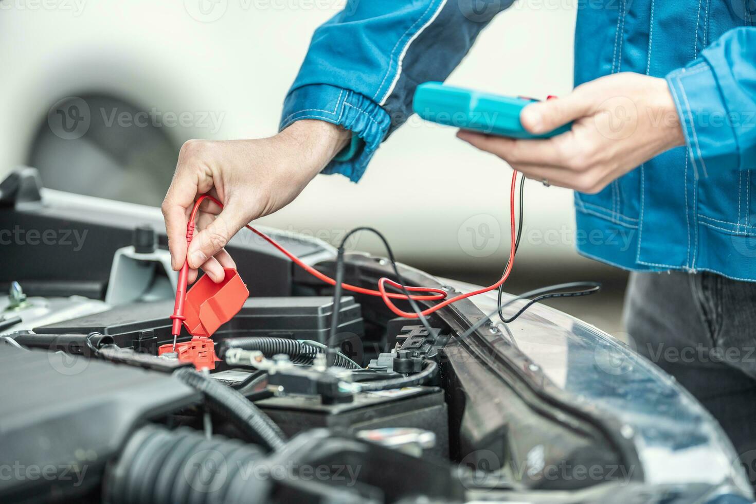 bil elektriker eller mekaniker checkar Spänning i bil batteri inuti de bil motor med öppen huva foto