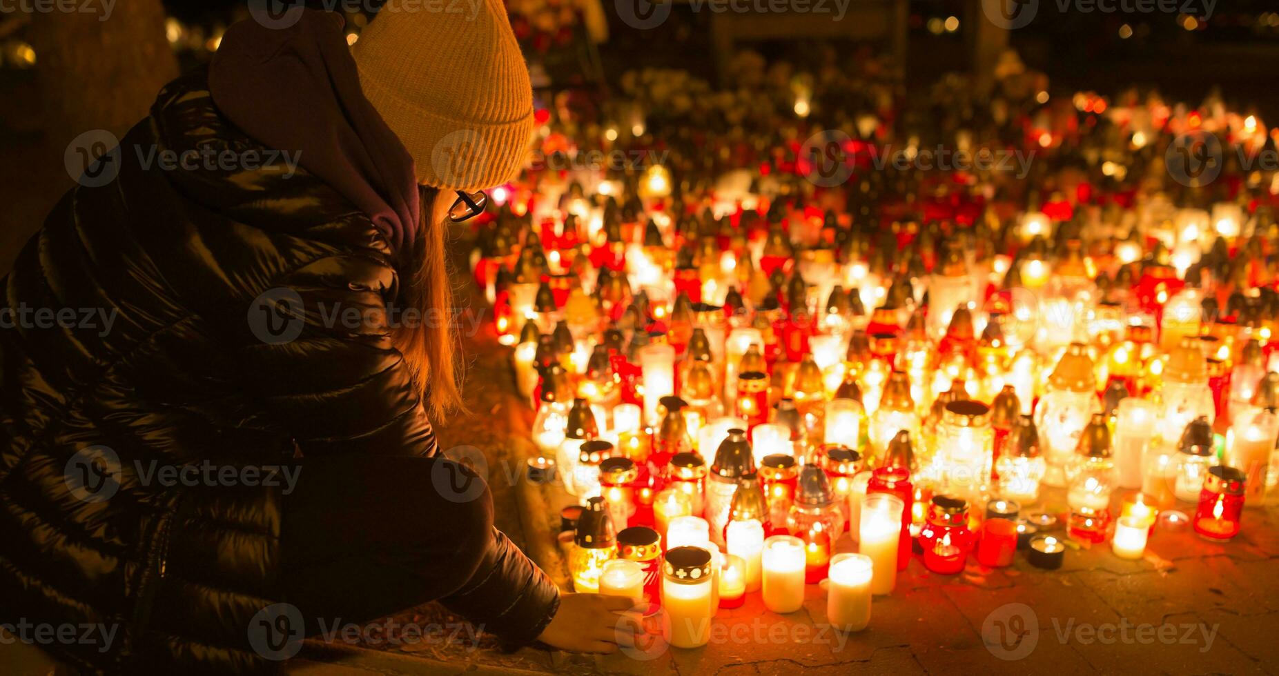 en ung flicka lampor en ljus på en religiös av Allt helgon dag foto