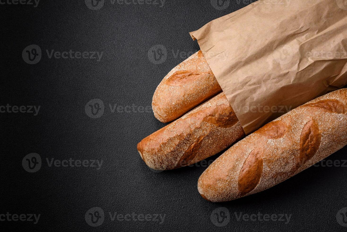 franska baguette bröd på en mörk texturerad betong bakgrund foto